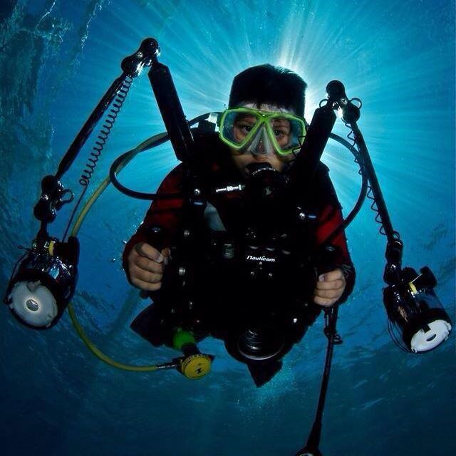 diver holding his camera underwater on the PADI course
